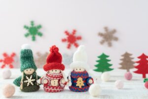 可愛いクリスマスカラーの服を着た３人の人形