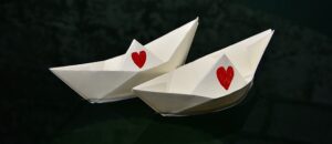 寄り添いながらそれぞれに進むふたりの折り紙の船